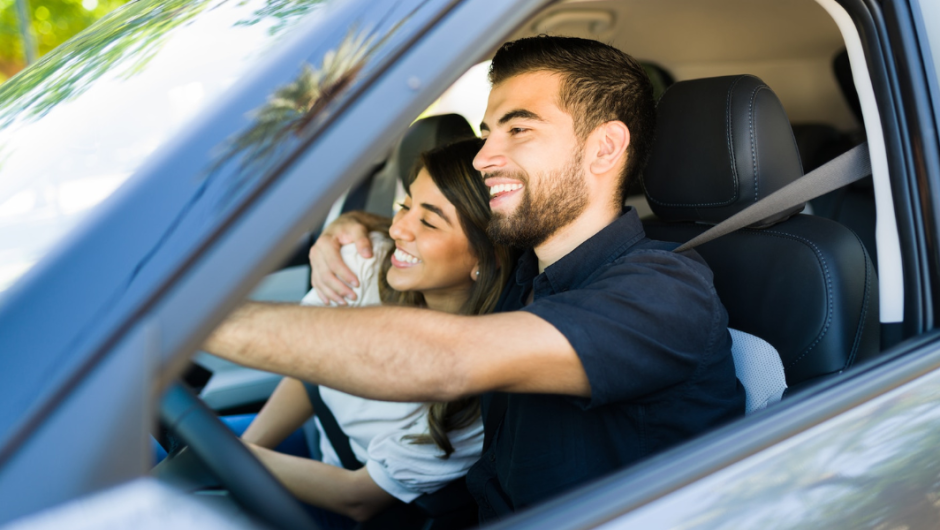 Hombre y mujer felices y sentados en un auto felices.